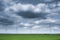 Dramatic blue sky over wind turbine on green grass Royalty Free Stock Photo