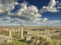 Dramatic blue sky with white clouds over the ruins of an ancient greek column at Histria, on the shores of Black Sea. Histria is Royalty Free Stock Photo