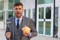 Dramatic businessman about to break his piggy bank Royalty Free Stock Photo