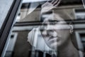 Dramatic close up portrait of young beautiful woman thinking and feeling sad suffering depression at home window looking depresse Royalty Free Stock Photo