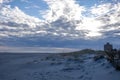 Dramatic cloud formation over a deserted beach with the dark blue sky peaking through a clearing in the clouds Royalty Free Stock Photo