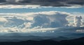 Dramatic cloud formation over mountain range blue sky sunlight scenic view Royalty Free Stock Photo