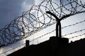 Dramatic clouds behind barbed wire fence on prison wall Royalty Free Stock Photo