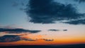 Dramatic clouds formatting storm in bright colors during sunset. Red, orange, purple sunset sky with clouds, fast motion