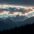 Dramatic clouds frame mountain peaks and towering trees in silhouette Royalty Free Stock Photo
