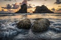 Dramatic clouds over sea stacks in Oregon and water splashing around rocks Royalty Free Stock Photo