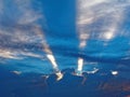 Dramatic clouds with sunbeams upwards into blue sky Royalty Free Stock Photo