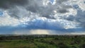 Dramatic clouds with sunlight breaking through over a cityscape and green fields. Bengaluru, India Royalty Free Stock Photo