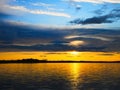 Dramatic clouds and sunset in blue and yellow over lake in Bemidji Minnesota