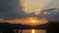 Dramatic clouds during sunset with clouds light rays over the mountains and river with reflections, Thailand Royalty Free Stock Photo