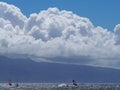 Dramatic clouds three windsurfers blue water