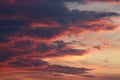 Dramatic clouds tinged with pink in sky at sunset