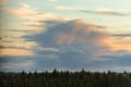 Dramatic cloudscape with cumulus clouds on sky at sunset above the forest horizon Royalty Free Stock Photo