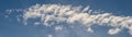 Dramatic cloudscape with fast moving white clouds against a blue sky, as a nature background Royalty Free Stock Photo