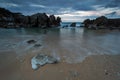 Dramatic cloudscape over rock formations in the sea and a sandy beach in Toro beach, Llanes, Spain