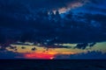 Dramatic cloudscape over water, sunset, sun almost went into the sea Royalty Free Stock Photo