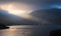 Dramatic cloudy seascape scenery with mountains illuminated with sunlight at Killary fjord in county Mayo, Ireland