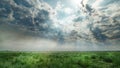 Dramatic cloudy sky over green field with sun rays Royalty Free Stock Photo