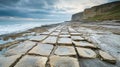 Dramatic coastal scene with natural stone pavement leading to cliffs under a cloudy sky Royalty Free Stock Photo