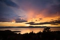 Dramatic and colorful sunset over Kvarner bay, with silhoueted trees in the foreground and the UÃÂka mountain