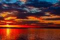 Dramatic colorful vibrant sunset sky with clouds reflected in the water Royalty Free Stock Photo