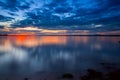 Dramatic colorful vibrant sunset sky with clouds reflected in the water Royalty Free Stock Photo