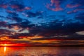 Dramatic colorful vibrant sunset sky with clouds reflected in the water Royalty Free Stock Photo