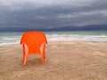 Empty beach with a lonely orange chair under a dramatic deep blue sky, the Dead Sea, Israel. Royalty Free Stock Photo