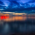 Dramatic colorful vibrant sunset sky with clouds reflected in the water Royalty Free Stock Photo