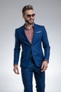 Dramatic cool guy in blue suit wearing sunglasses and posing