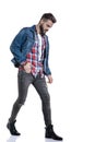 Dramatic cool guy in plaid shirt holding hand in pocket and walking Royalty Free Stock Photo