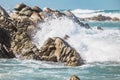 Dramatic crashing wave hitting rocks on the shore.