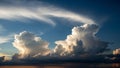 Dramatic cumulus and cirrus clouds illuminated by golden hour sunlight against a deep blue sky Keywords: clouds, sky Royalty Free Stock Photo