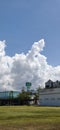 Dramatic Cumulus Clouds Over Industrial Buildings on a Sunny Day Royalty Free Stock Photo