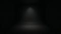 Dramatic dark background studio interior featuring a subtle spotlight illuminating the empty floor space ideal for product display Royalty Free Stock Photo