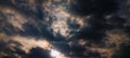 Dramatic dark clouds with a bright sunlight peak. A moody and beautiful stormy sky. Royalty Free Stock Photo