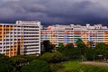 Dramatic dark grey clouds over colourful HDB flats in Singapore heartland