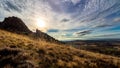 Dramatic dark mountain Madrid landscape with clouds and sun in front, rocks and plants