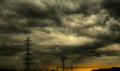 Dramatic dark sky and clouds and high voltage pole with electric cable. Cloudy sky background. Black sky before thunder storm.