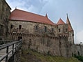 Corvin Castle in Hunedoara under cloudy sky