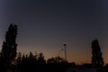 Dramatic dawn sky with black trees silhouettes and street lamp. Night landscape with deep cold and warm colors gradient Royalty Free Stock Photo