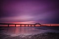 Dramatic deep purple clouds pre dawn over a bridge stretching across a body of water. Fire Island Inlet Bridge - Long Island NY Royalty Free Stock Photo