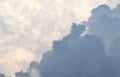 A dramatic diagonal contrast between a heavy, dark grey storm cloud and a bright, ethereal mass of sunlit white clouds Royalty Free Stock Photo