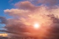 Dramatic sunset storm sky with cumulus clouds, orange sun and sunlight on blue sky background Royalty Free Stock Photo