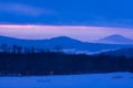 Dramatic evening cloudscape in city  red and blue sky  mountains and fogs in a sunset. Royalty Free Stock Photo