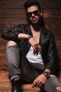 Dramatic fashion man in leather jacket and sunglasses sitting Royalty Free Stock Photo