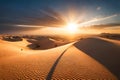 A dramatic, fiery sunrise over a rugged desert landscape, casting long, dramatic shadows over the sand dunes