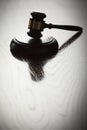 Dramatic Gavel Silhouette on Reflective Wood Royalty Free Stock Photo