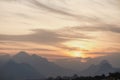 Dramatic golden sunny evening cloudscape with misty high mountains