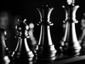 Dramatic grayscale shot of chess figures lit in the darkness